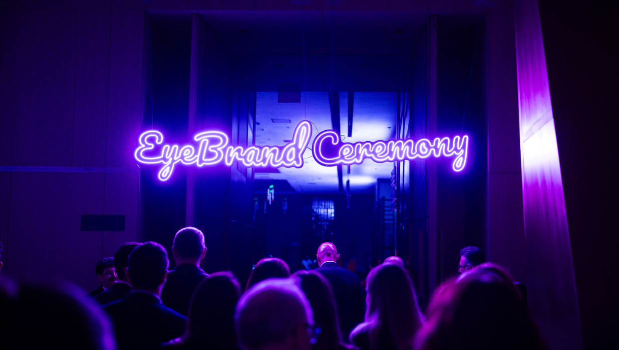 Davetliler EyeBrand Ceremony yazan kapıdan içeri giriyor.